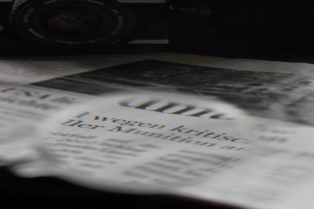 Zeitungsausschnit mit Lupe 