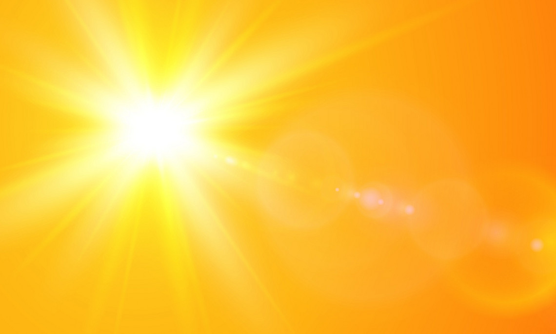 gelbe, strahlende Sonne vor orangem Hintergrund