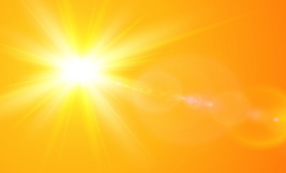 gelbe, strahlende Sonne vor orangem Hintergrund