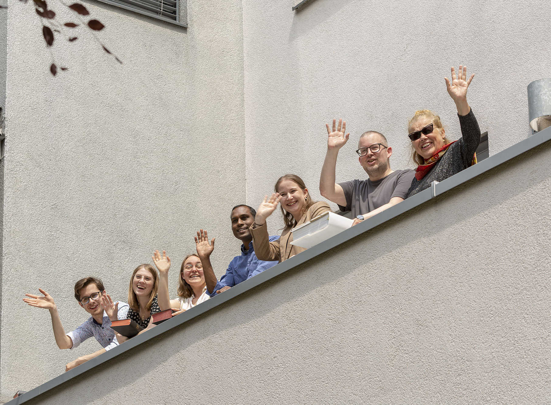 Theologie-Studierende winken vom Balkon des UZT ©lichtmeister.com