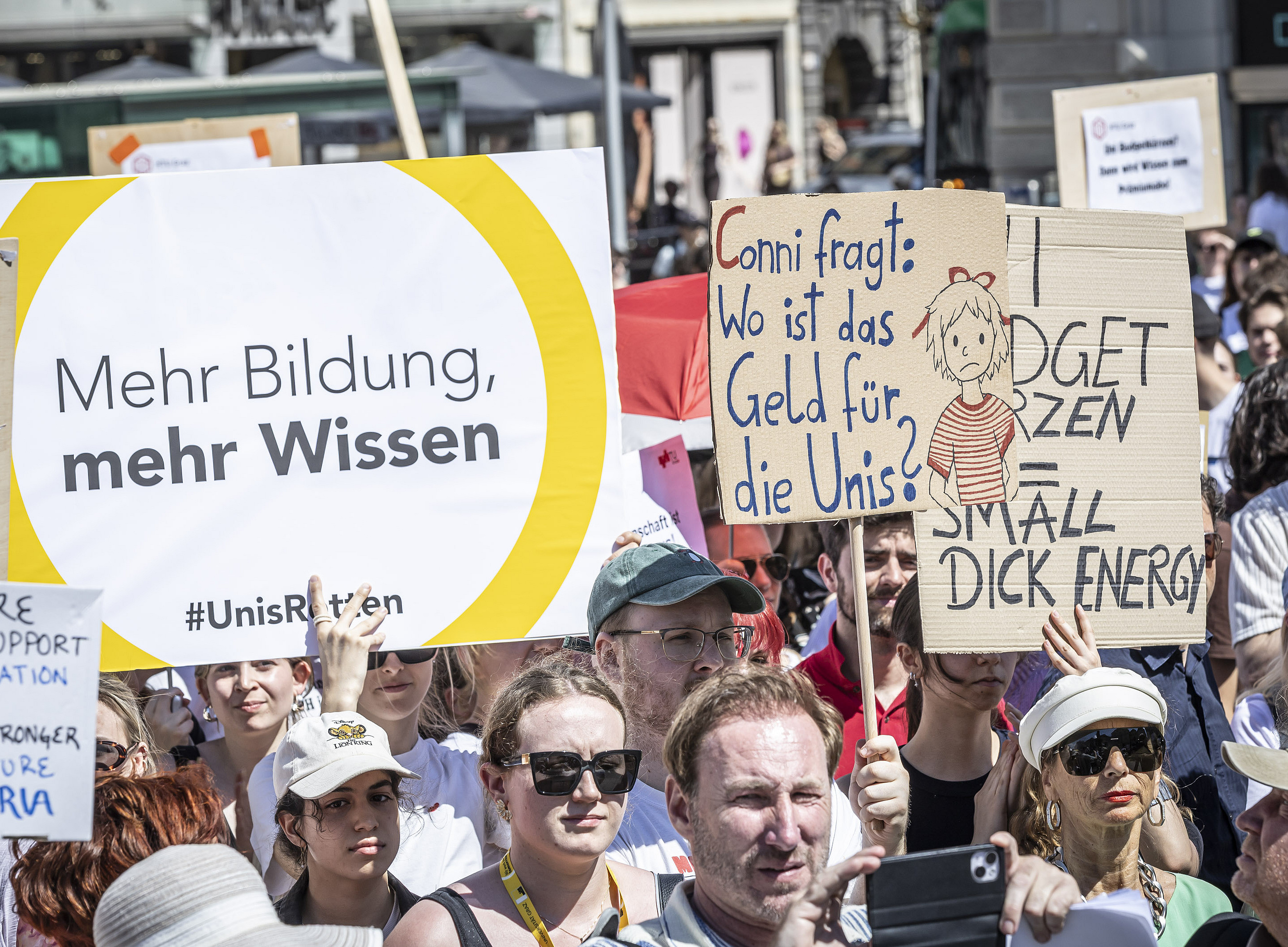 A crowd at a demonstration; many young adults are holding up placards calling for more funding for education and universities. ©Foto Fischer