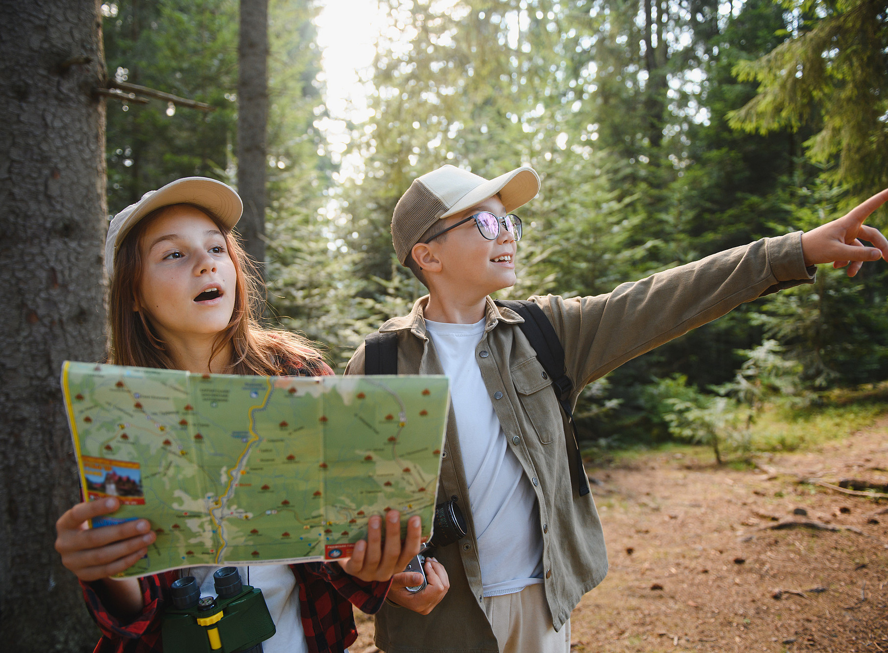 Zwei Kinder mit Landkarte im Wald 