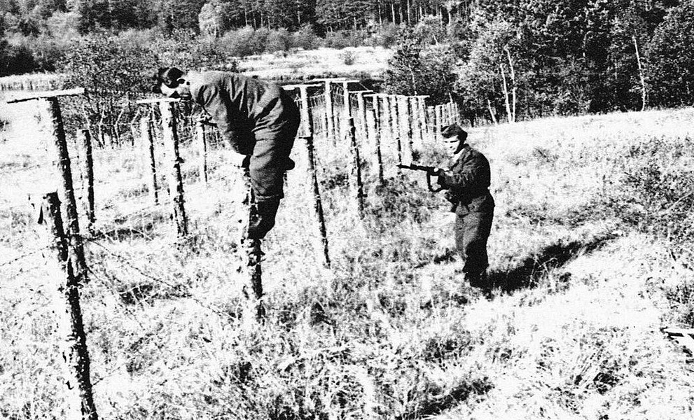 Die tschechoslowakische Grenzwache Pohraniční stráž greift einen Flüchtling am Eisernen Vorhang auf.