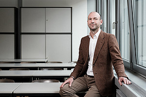 Peace researcher Maximilian Lakitsch sitting in an empty lecture hall