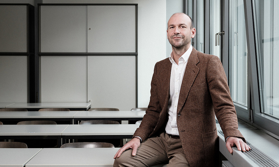 Peace researcher Maximilian Lakitsch sitting in an empty lecture hall