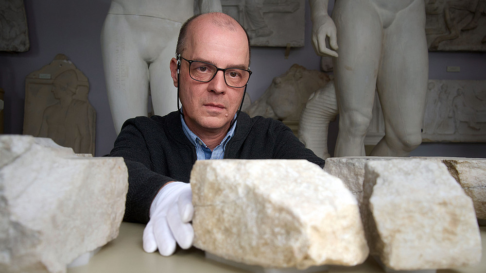 Stephan Karl mit Bruchstücken aus Marmor ©Uni Graz/wildundwunderbar