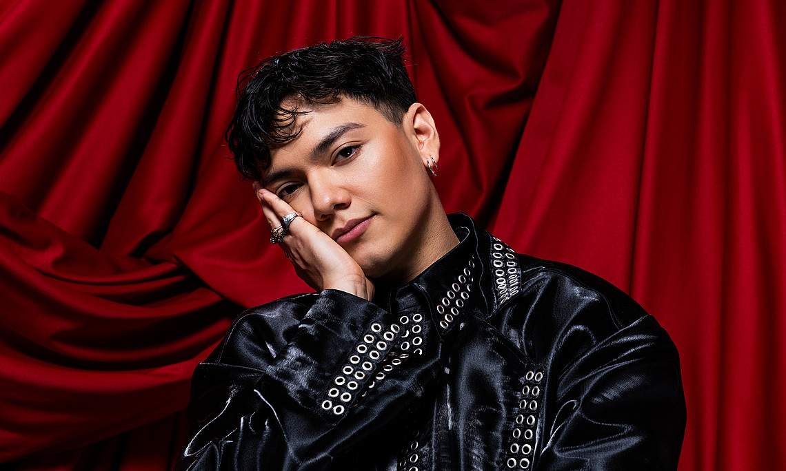 Austria's Song Contest starter JJ in front of a red curtain