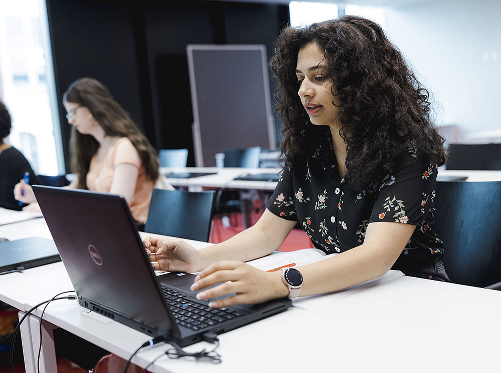 Eine Studierende sitzt vor einem Computer in einem Seminarraum und schaut konzentriert ©Uni Graz/Kanizaj