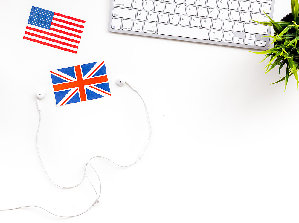 computer keyboard, headphones, british and american flags on white background top view copy space ©By 9dreamstudio; stock.adobe.com