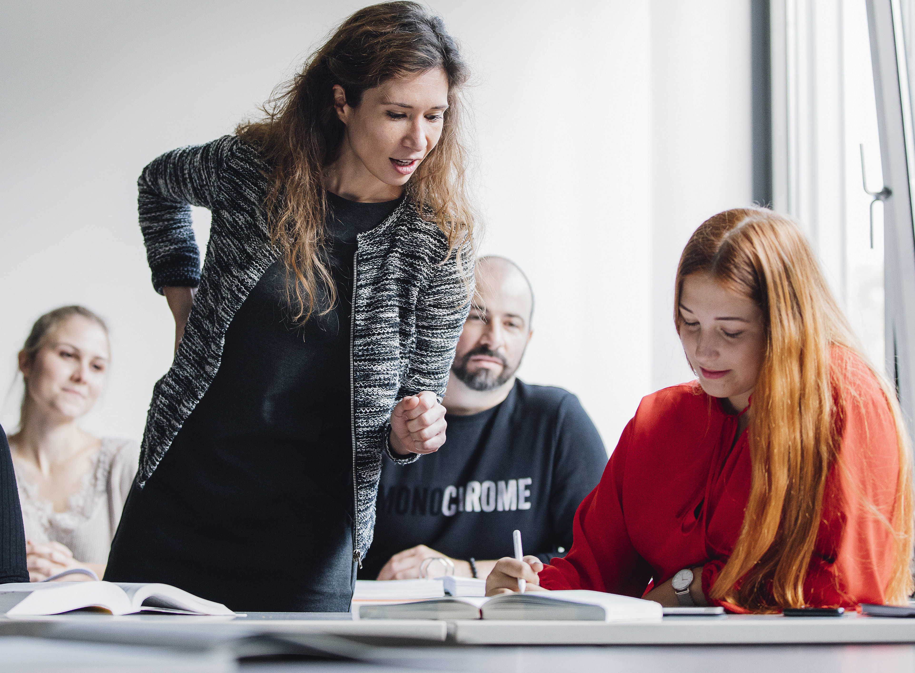 Eine Gruppe von Doktorand:innen und Nachwuchswissenschaftler:innen sitzt in einem Klassenzimmer und hört ihrer Mentorin zu. ©Uni Graz