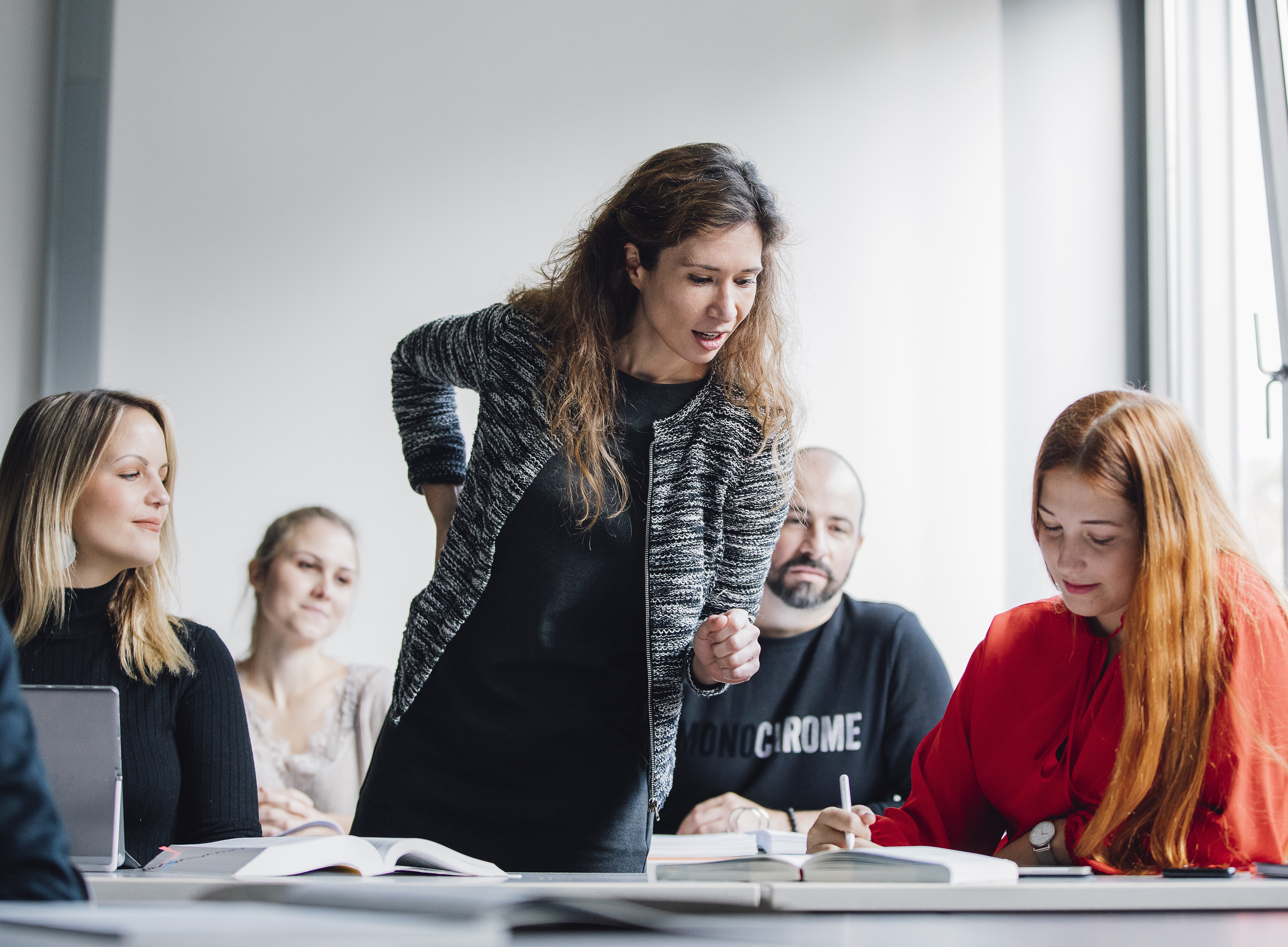 Eine Gruppe von Doktorand:innen und Nachwuchswissenschaftler:innen sitzt in einem Klassenzimmer und hört ihrer Mentorin zu. ©Uni Graz