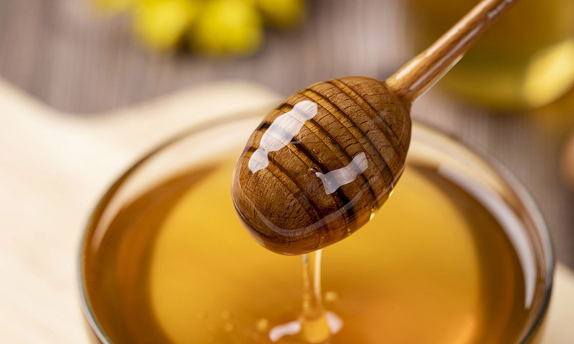 Schale mit Honig und Löffel, von dem der Honig zurück in die Schale rinnt. Foto: Pixabay/Gasfull