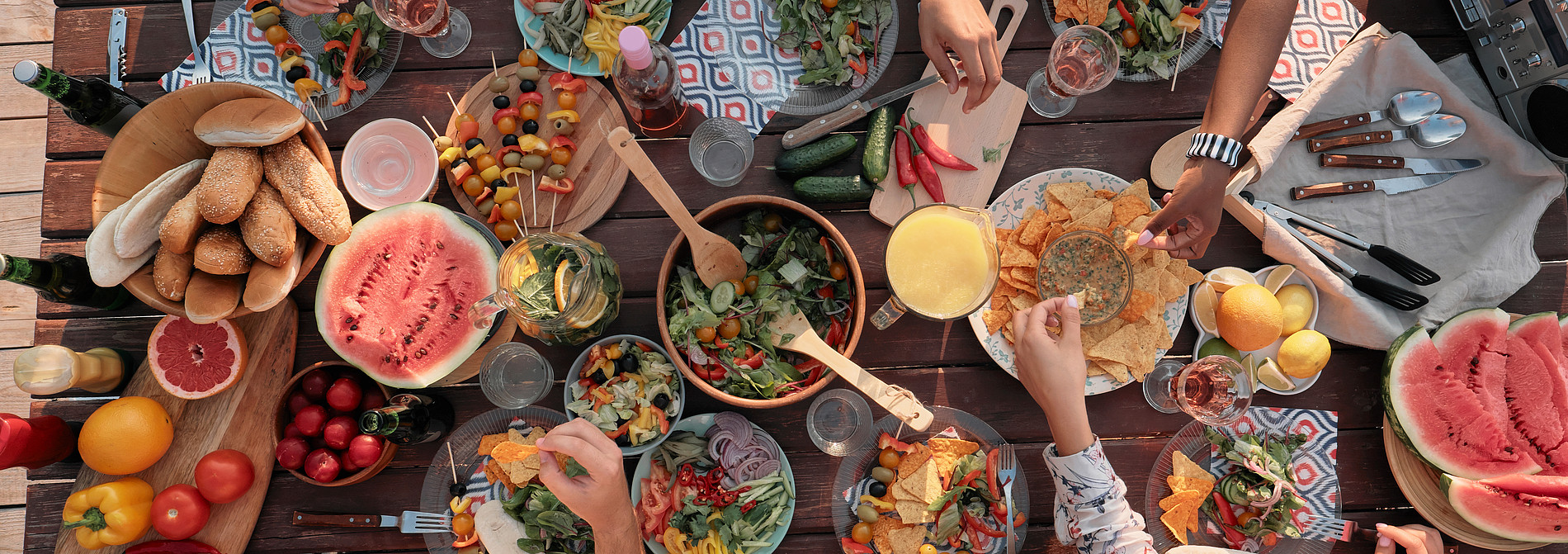 Gruppe von Menschen wie sie an einem Tisch essen. ©AnnaStills - stock.adobe.com 