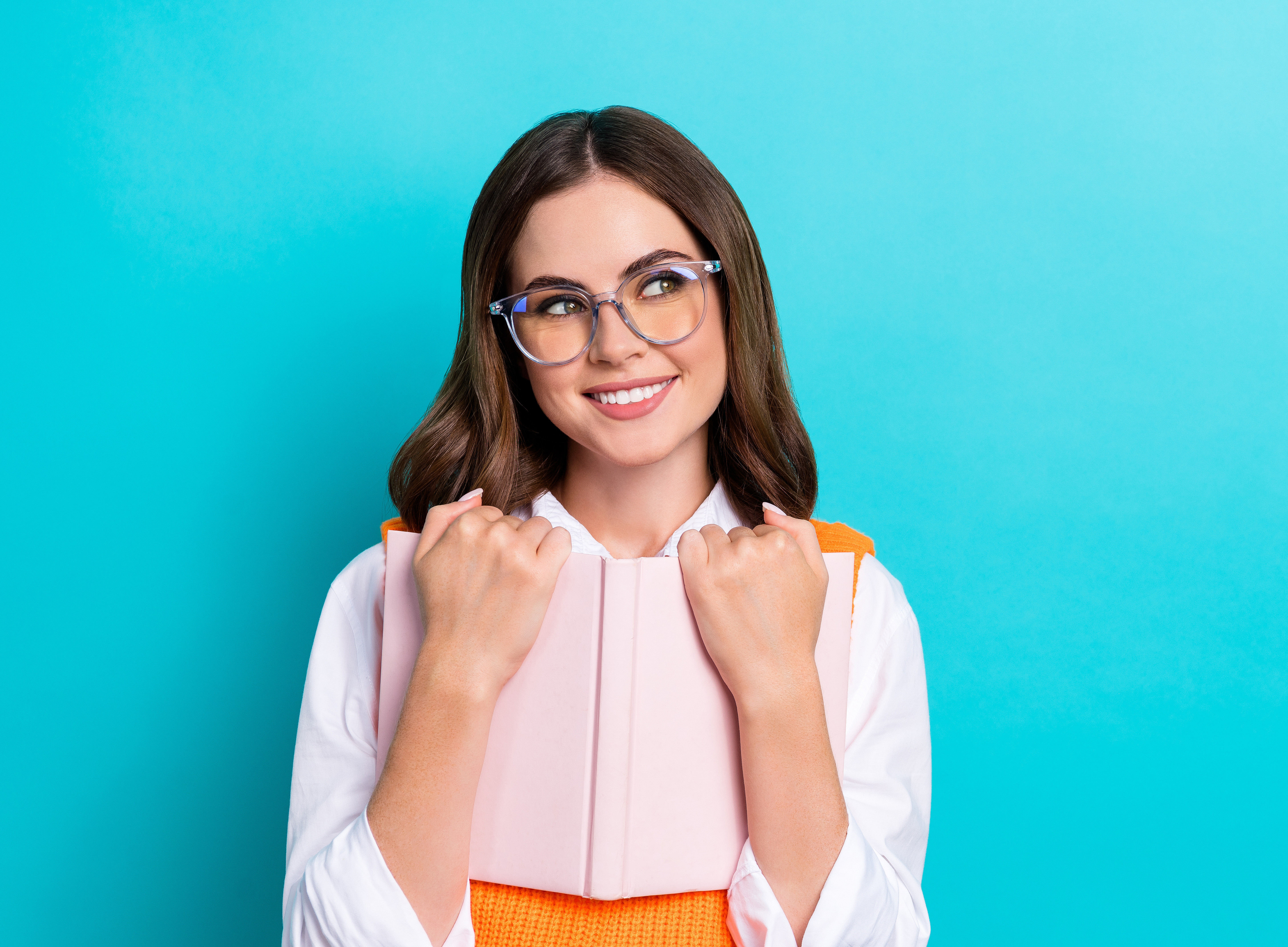 Photo of young beautiful learner college girl wear orange vest shirt specs hold diary look empty space book shop isolated on cyan color background 