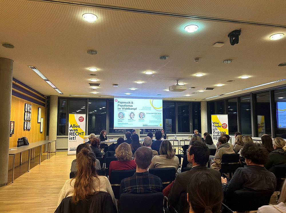 ©Uni Graz/Zankel Bilder der Veranstaltung Populismus und Popmusik. Viele Leute auf Stühlen und das Podium im Hintergrund ©Uni Graz/Zankel