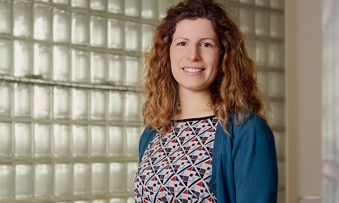 Mathematikerin Federica Caforio vor einer Wand aus Glasziegeln