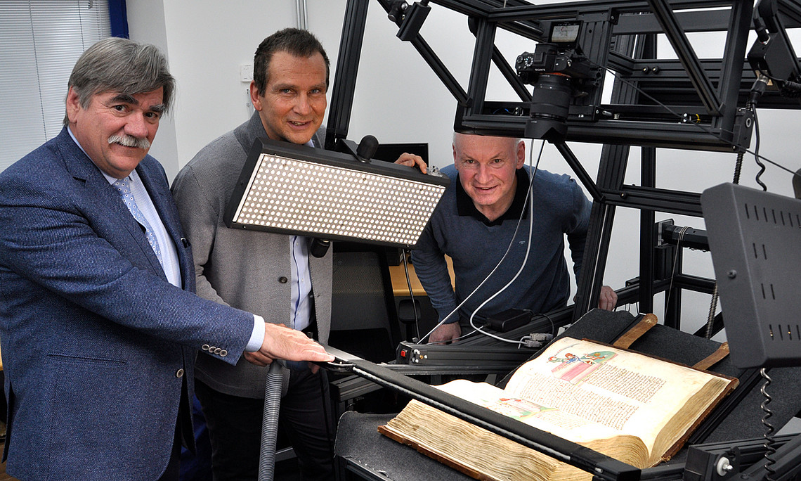 Die Vorauer Bibel bereit für den Scan: UB Graz-Leiter Werner Schlacher, Karl Lenger und der Vorauer Archivar Stefan Reiter in der Digitalisierungsstelle der Bibliothek. Foto: Uni Graz/Tzivanopoulos
