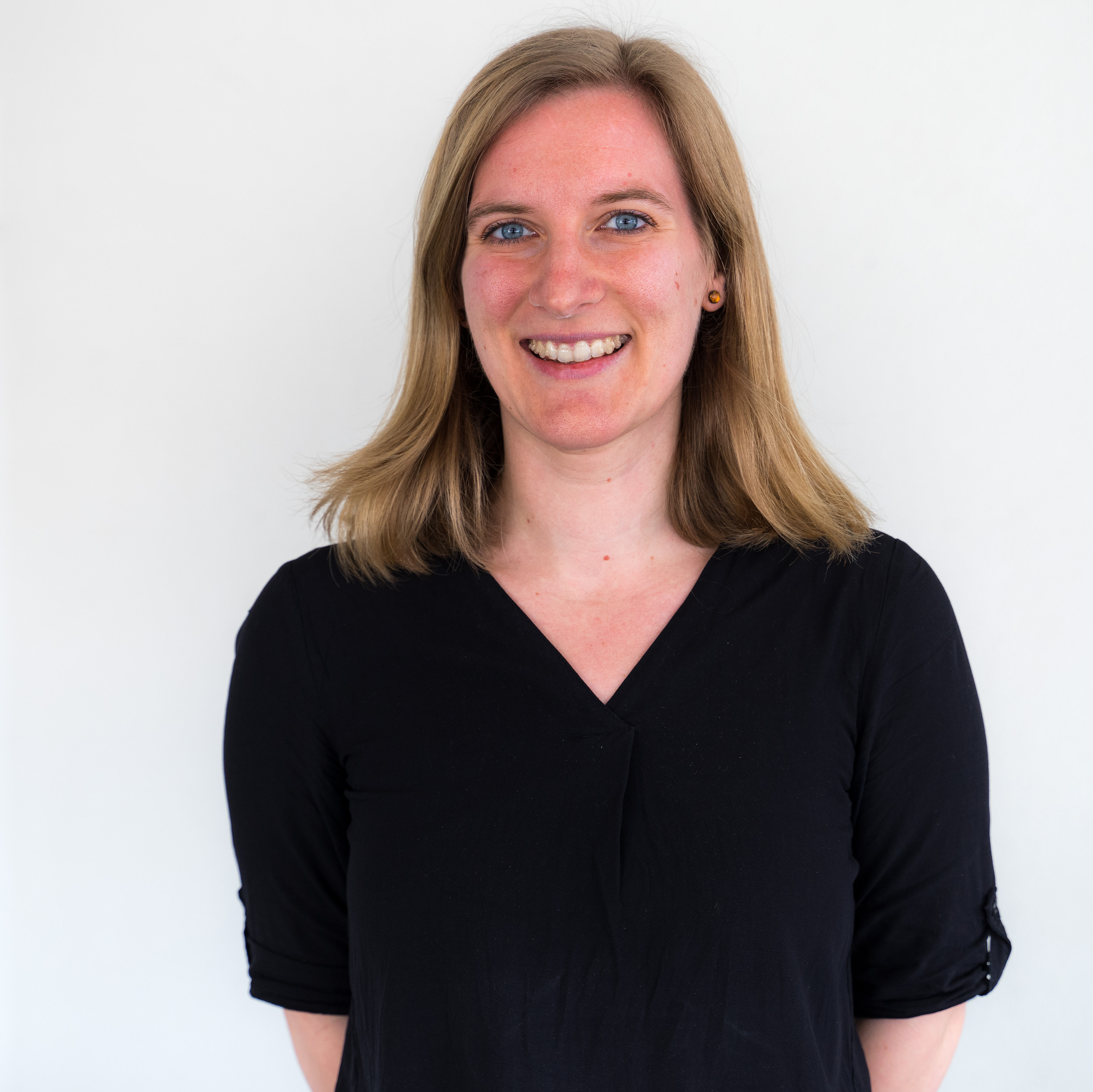 Junge Frau mit hellen Haaren und schwarzer Bluse