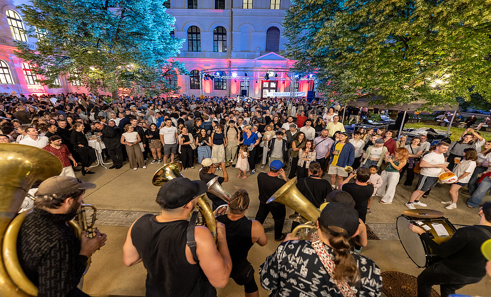 Band spielt, dahinter viele Menschen in einem Innenhof