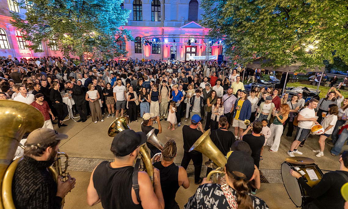 Band spielt, dahinter viele Menschen in einem Innenhof