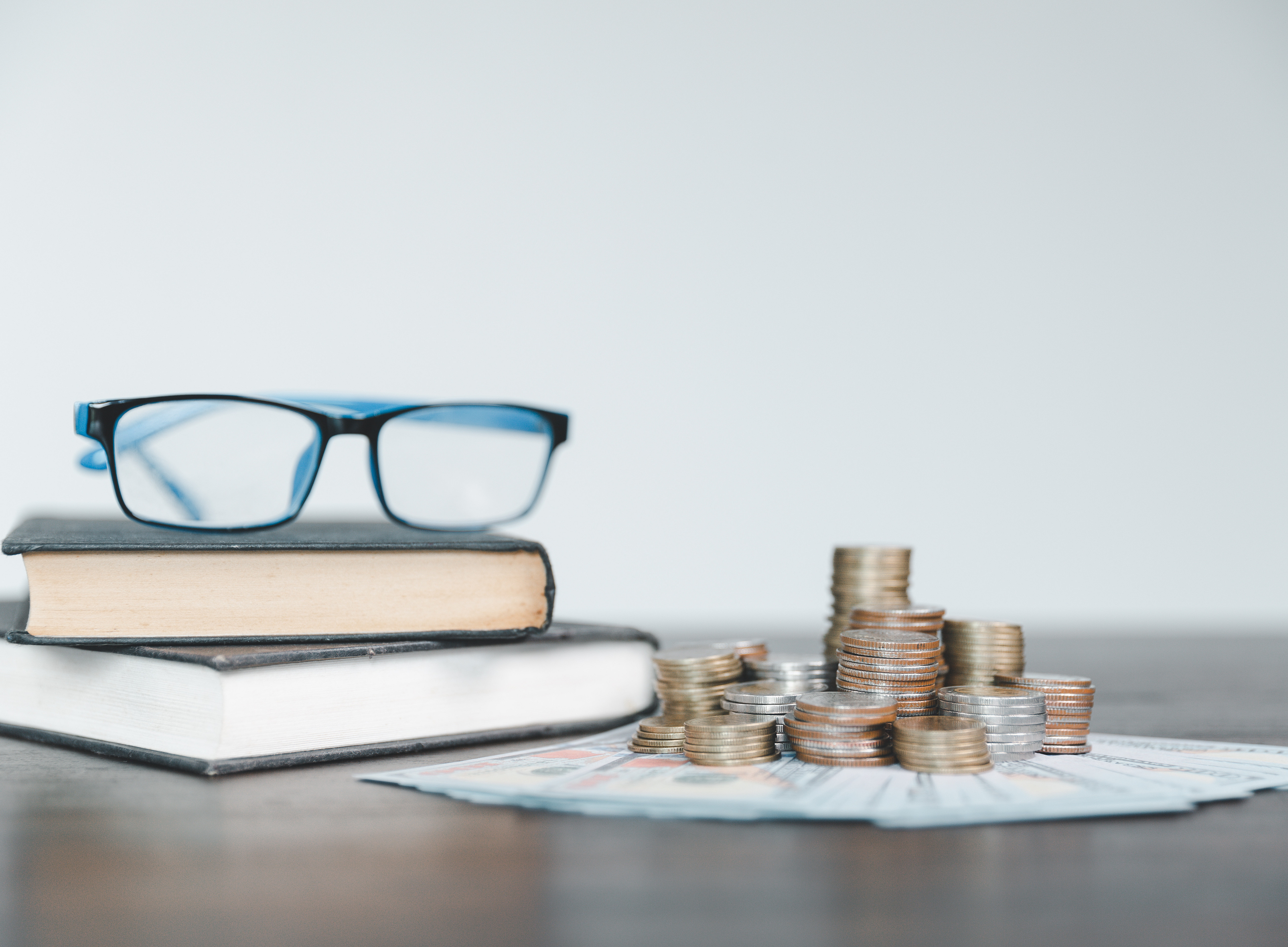 Stockphoto with books and coins and glasses 