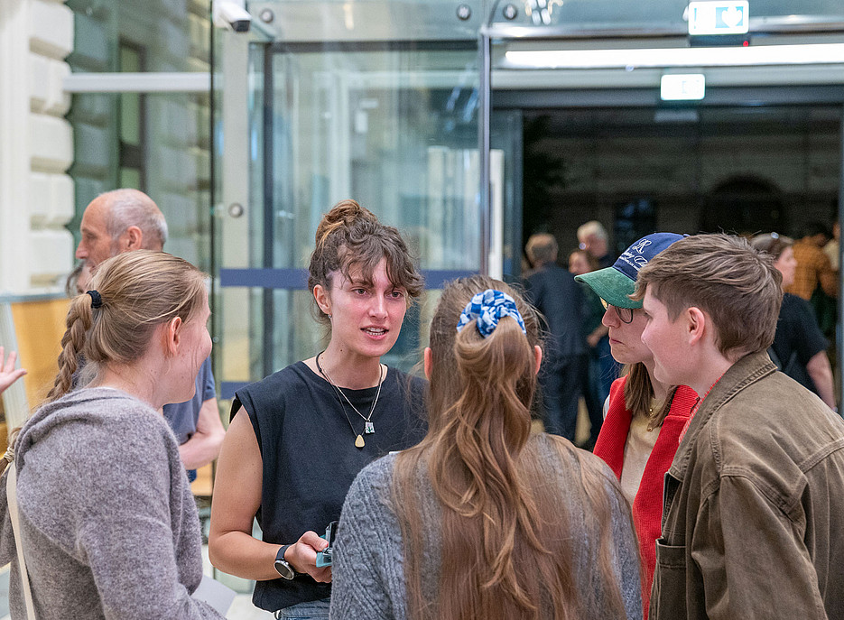 A researcher speaks with three visitors at the Long Night of Research ©Uni Graz/Weber