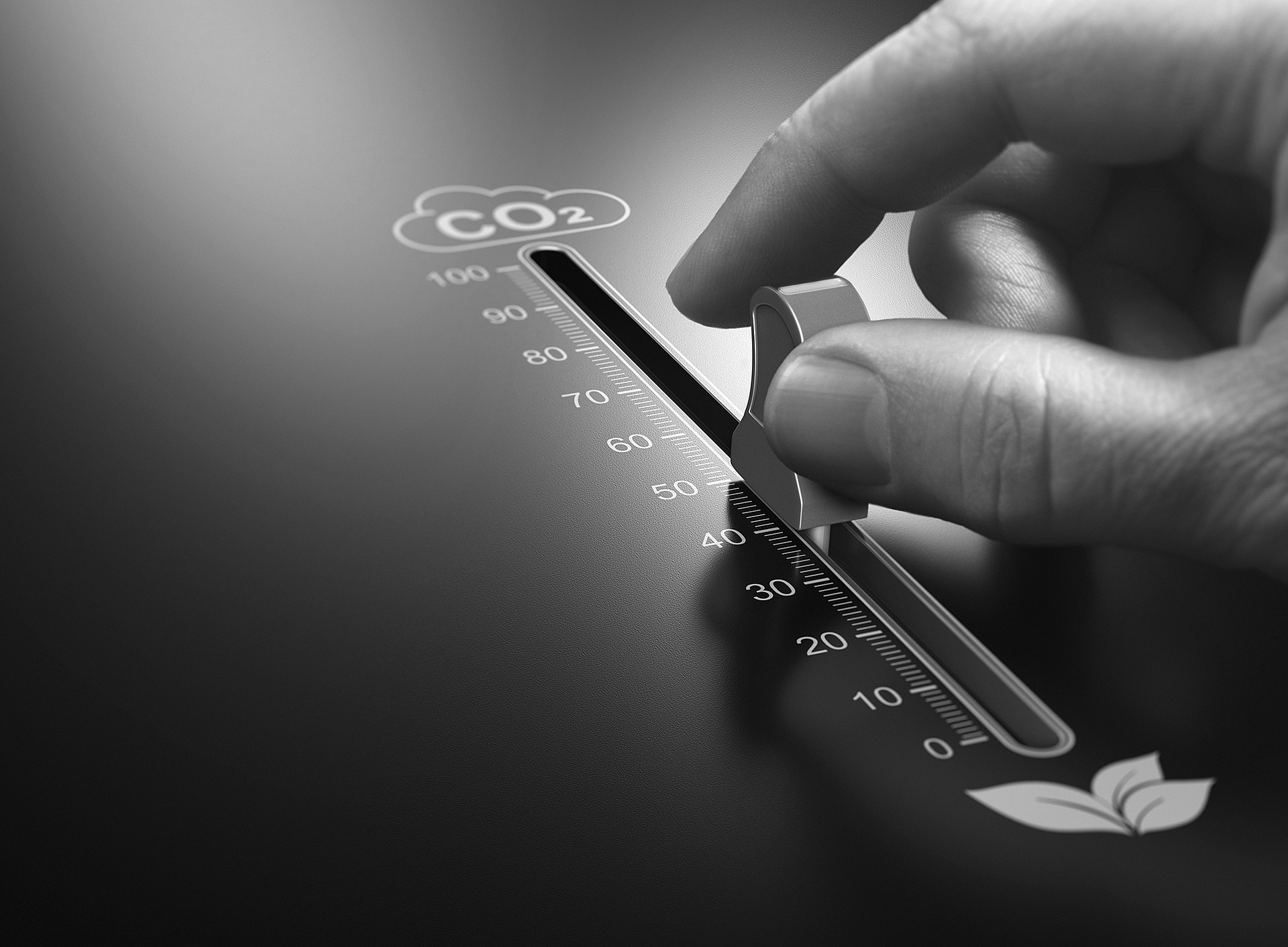 Hand stellt einen Schieberegler mit Skala von 0 bis 100 und der Beschriftung „CO₂“ auf etwa 35, unten rechts ein Blattsymbol. ©Olivier Le Moal - stock.adobe.com