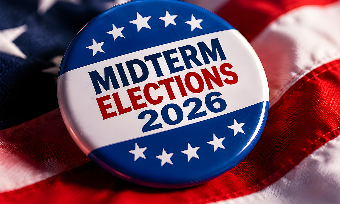 Ein runder Button mit der Aufschrift „Midterm Elections 2026“ liegt auf einer amerikanischen Flagge. Der Button ist in den Farben Blau, Weiß und Rot gestaltet und zeigt mehrere weiße Sterne.