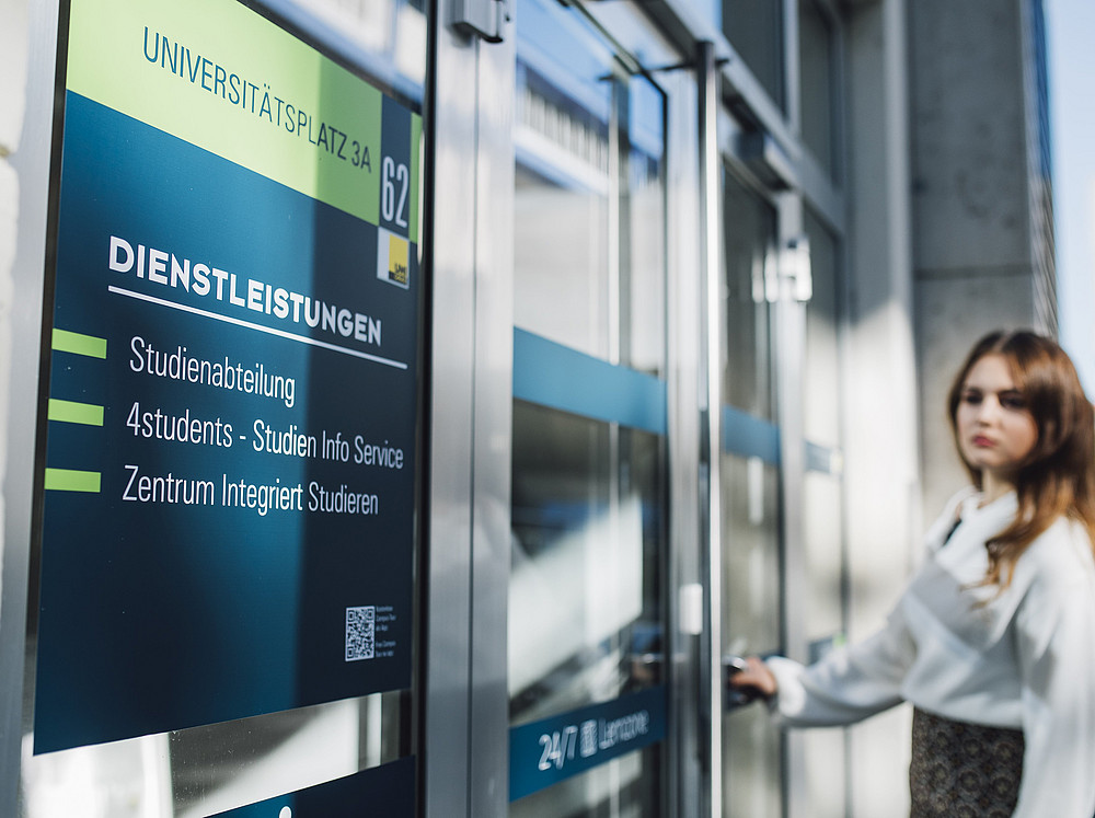 A young woman opens the door to the building ©Uni Graz/Kanizaj