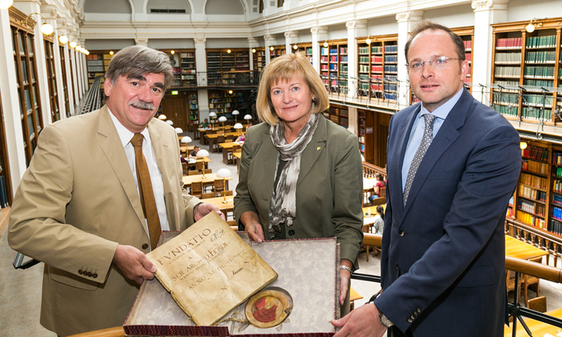 Noch ein Gruppenbild vorm großen Umbau: UB-Leiter Werner Schlacher, Rektorin Christa Neuper und Maximilian Pammer von der BIG (v.l.) mit einer Abschrift der Gründungsurkunde der Universität Graz aus dem Jahr 1602. Ab Herbst bleibt der Bibliotheks-Stand