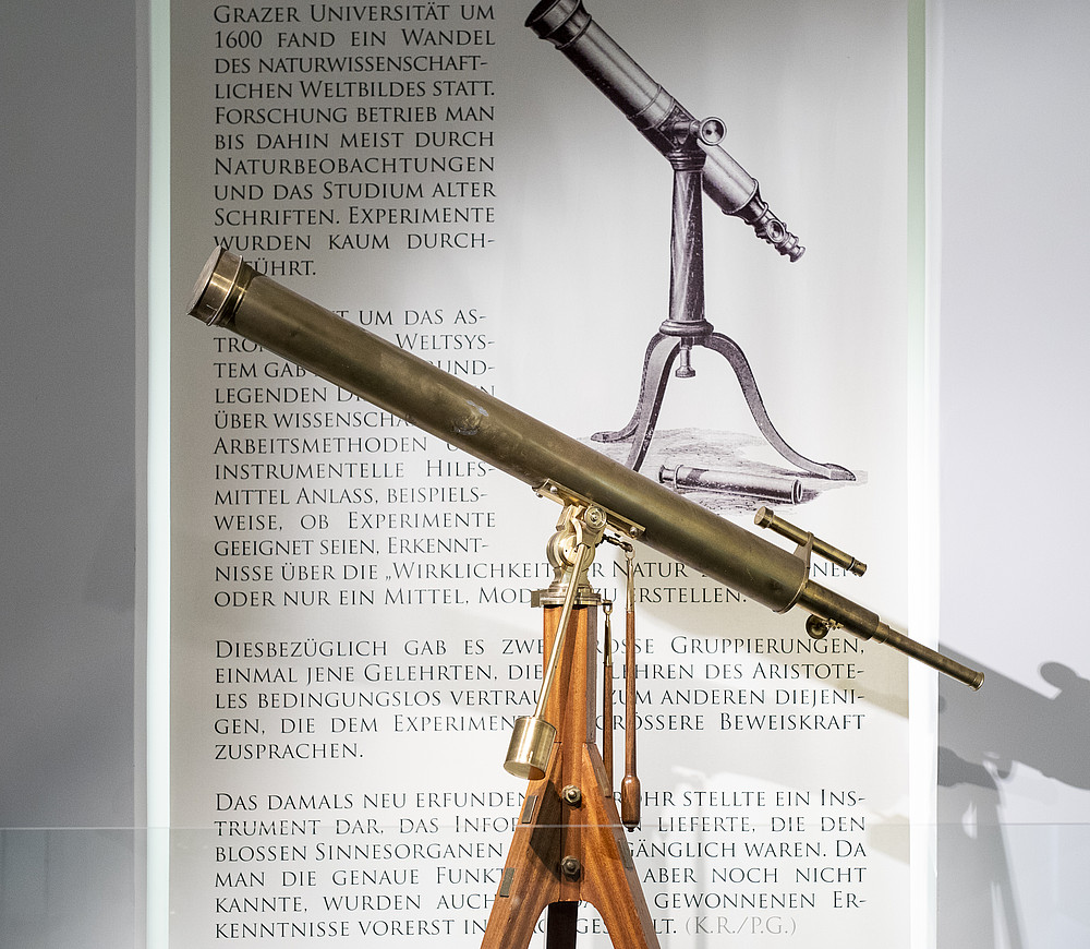 Universitätsmuseen zeigen beim Objekt der Woche das Astronomische Fernroh auf einem Stativ vor einer erklärenden Tafel mit Text ©KANIZAJ | 2019