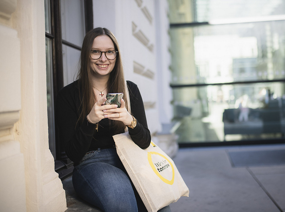 Eine Studentin nutzt ihr Handy am Campus mit WLAN. ©Uni Graz/Tzivanopoulos