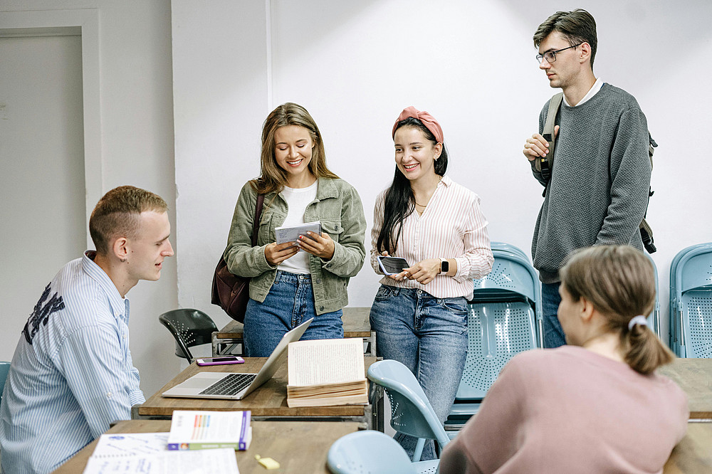 studierende stehen um tisch ©Ivan Samkov | pexels