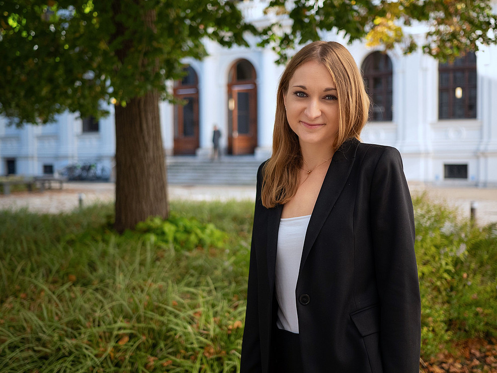 Anna Zaversky, Universitätsassistentin am Institut für Arbeitsrecht und Sozialrecht, steht im Innenhof der Universität ©Uni Graz/Radlinger