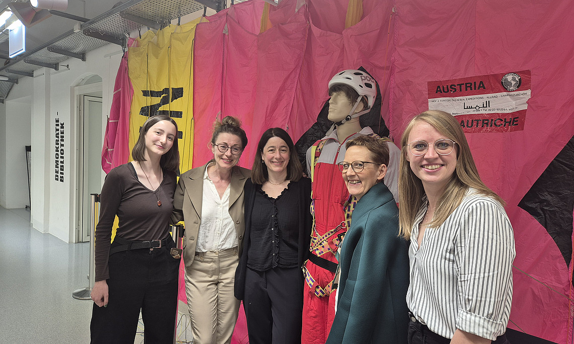 Universitätsmuseen - fünf Frauen stehen vor einem gelb-pinken Paragleitschirm 