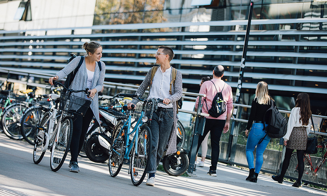 Studierende mit Fahrrad am Campus der Uni Graz