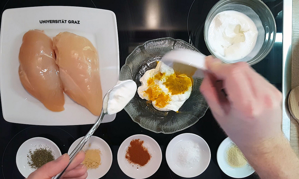 Ein mit Joghurt mariniertes Huhn. Fritz Treiber zeigt wie es geht. Foto: Uni Graz