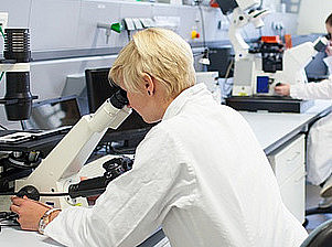 Woman looking through a microscope in a laboratory, symbolizing the Department of Pharmaceutical and Medical Technology ©BioTechMed-Graz