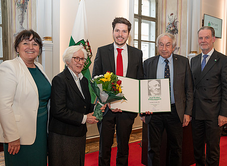 Eine Gruppe von fünf Menschen, ein Mann in der Mitte hält eine Urkunde. ©LandSteiermark/Binder