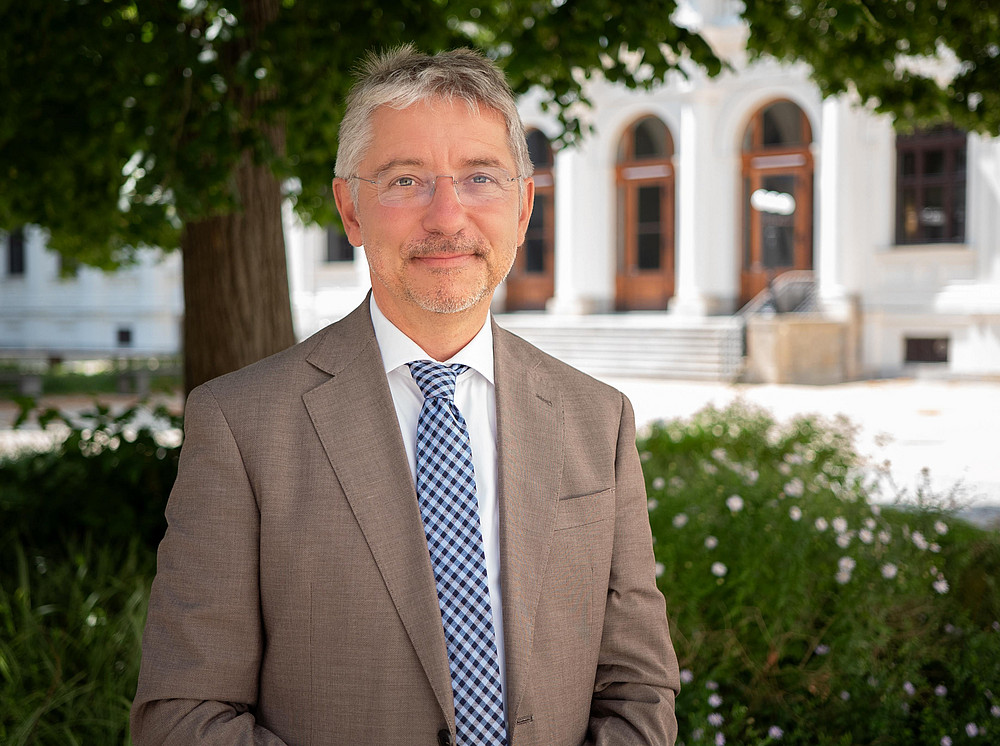 Christian Aschauer im Portrait im Innenhof der Hauptgebäude der Universität Graz 