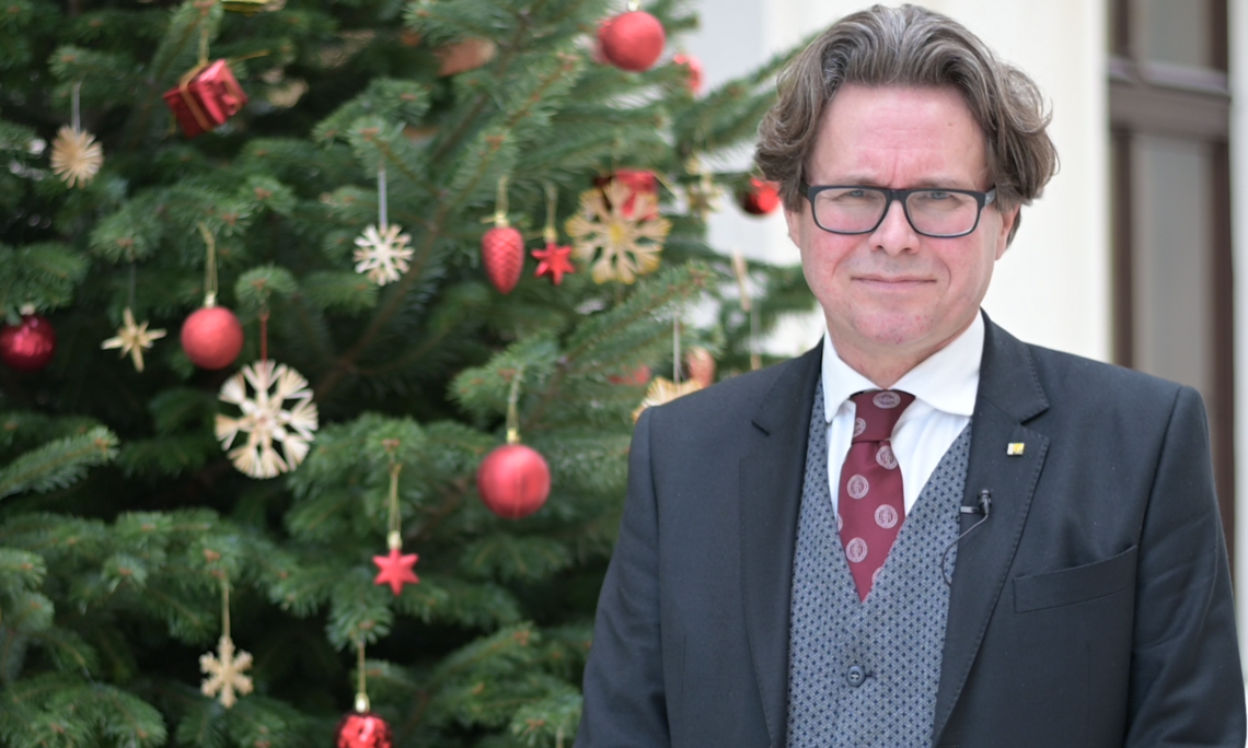 Rektor Polaschek mit Weihnachtswünschen aus dem Foyer der neuen Universitätsbibliothek. Foto: Koppelhuber/Uni Graz