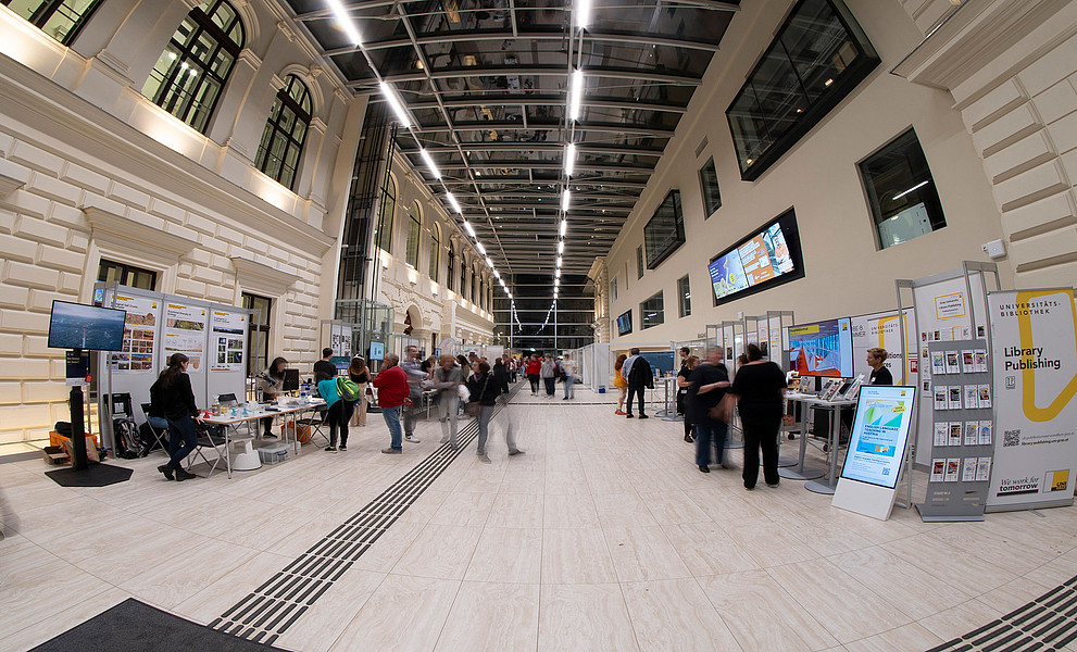 Nächtliches UB-Foyer durch ein Fischauge fotografiert mit Mitmach-Stationen und Besucher:innen bei der Langen Nacht der Forschung