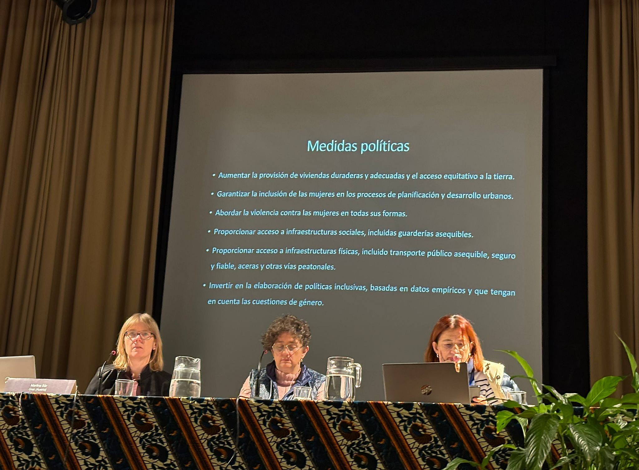 Podium mit drei Personen, die Vorträge halten 