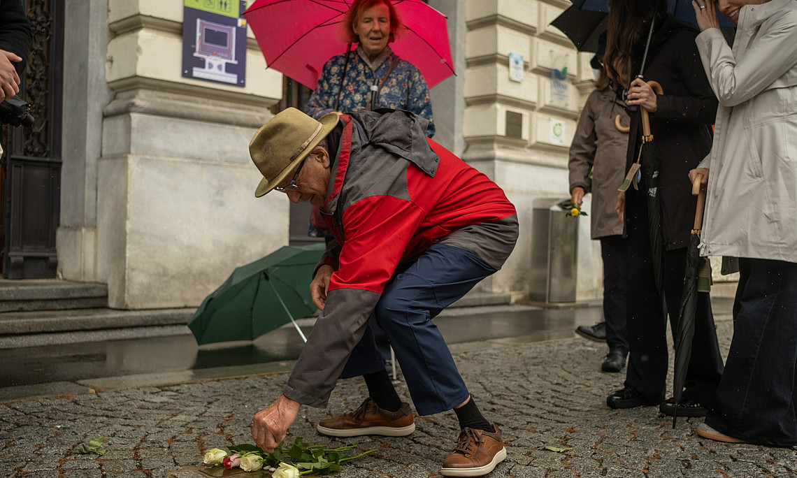 Ein Mann legt Blumen auf den Boden