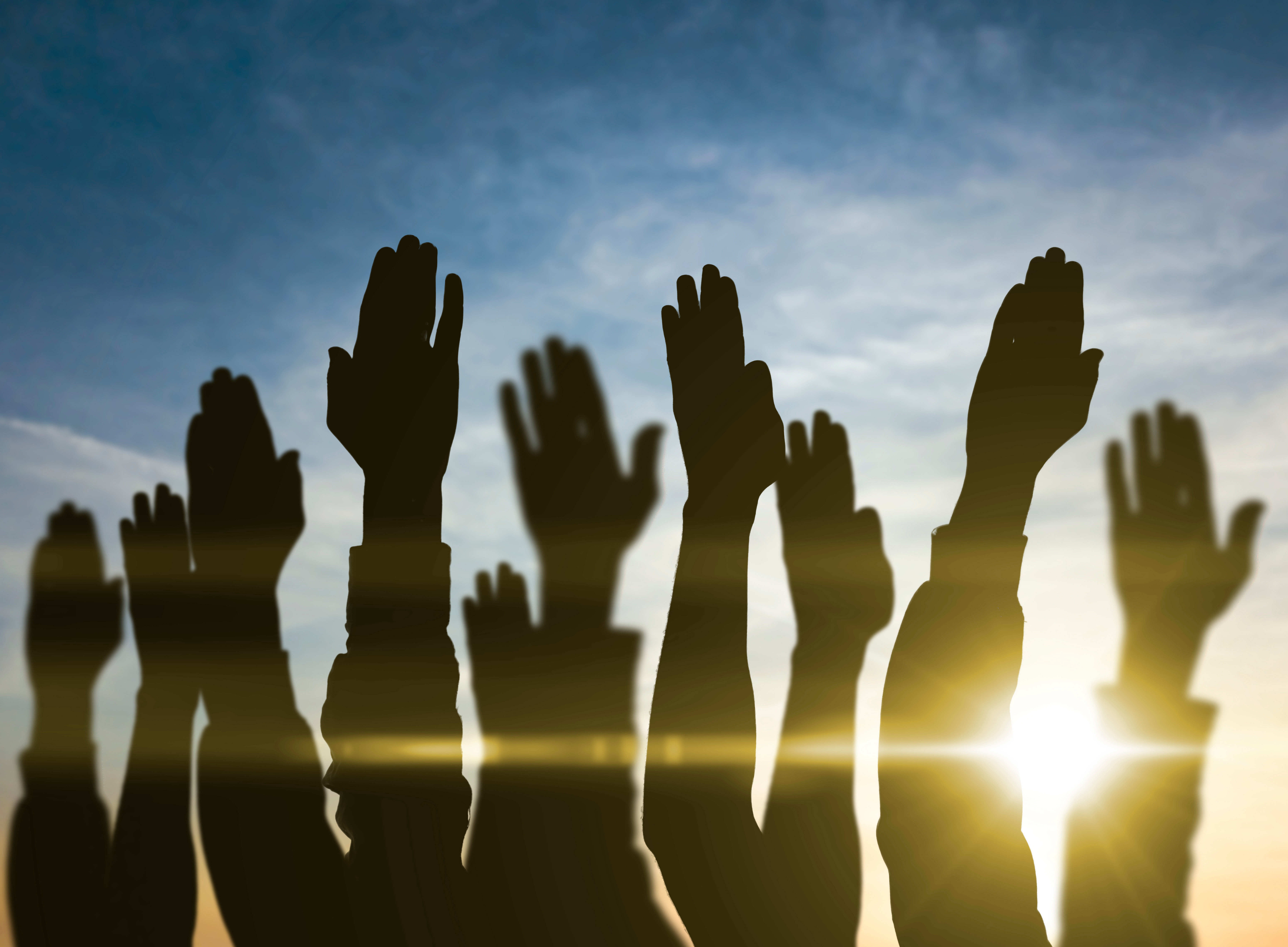 Hände von Personen, die sich zum Himmel strecken 