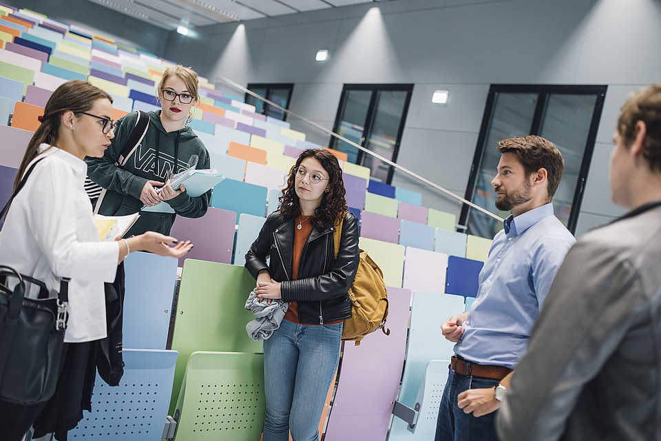 Professor mit Studierenden im Hörsaal