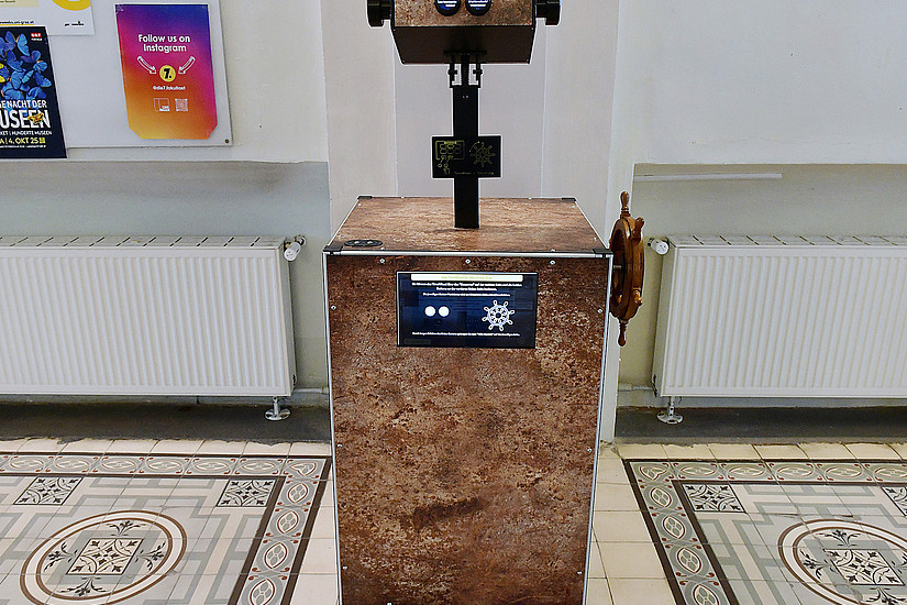 the Time Wheel, a metal box with an eyepiece, a wheel for turning on the side, two buttons and a display on the front