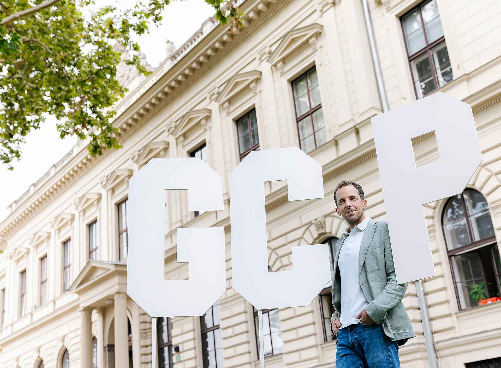 ein Mann steht vor einem historischen Gebäude sowie drei sehr großen Buchstaben G C P ©KANIZAJ photography 2024
