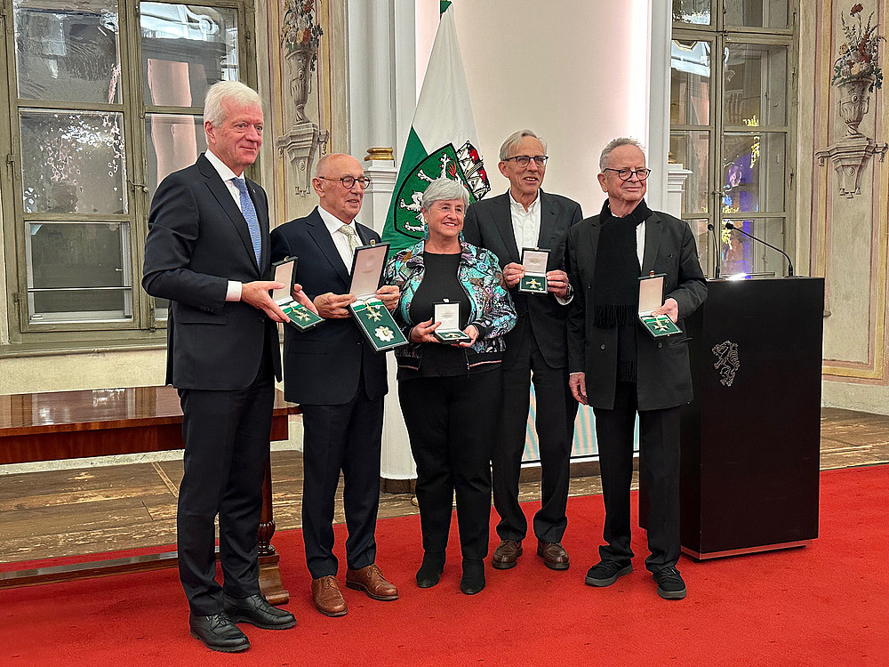 eine Frau und 4 Männer, die nebeneinander stehen und Ehrenzeichen des Landes Steiermark in den Händen halten 