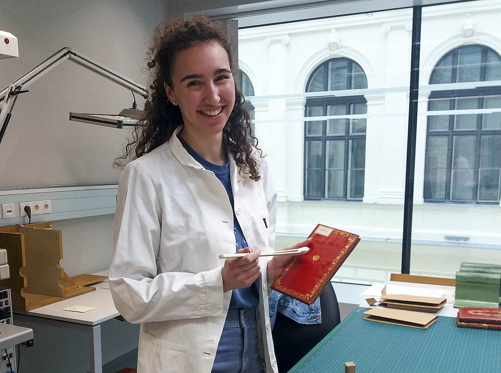 Intern holds book ©Uni Graz/Zammit-Lupi